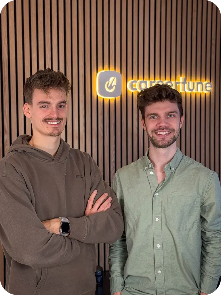 Die Careertune Gründer Felix Hüsgen und Finn Prietzel vor einer Wand mit leuchtendem Careertune Logo