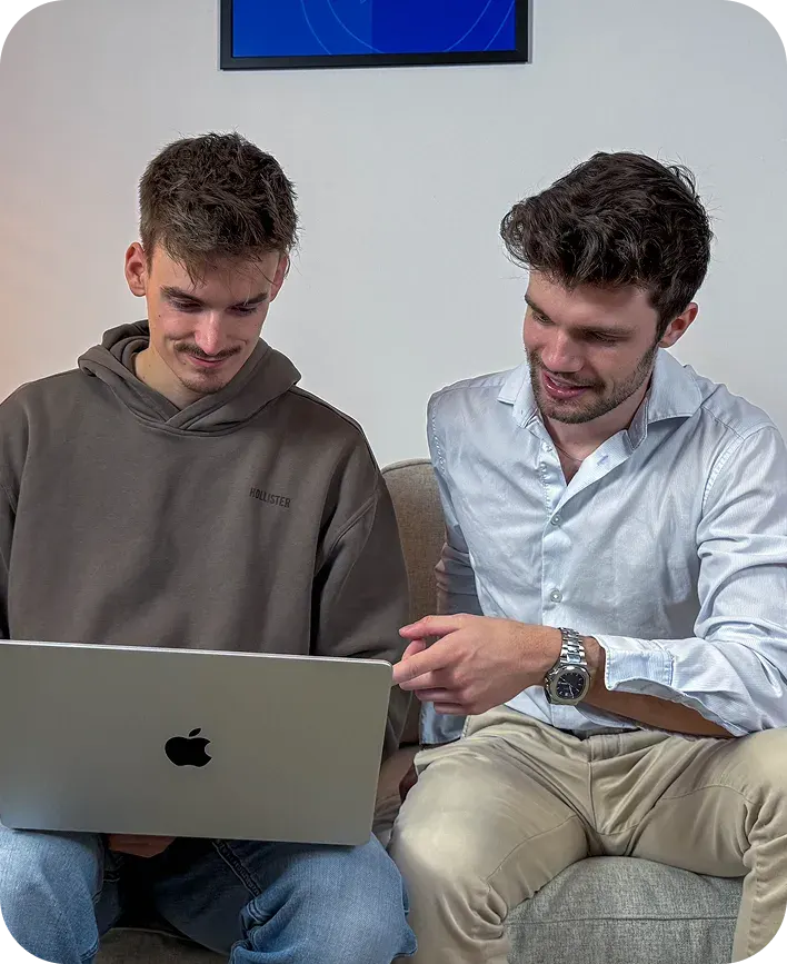 Die Careertune Gründer Finn Prietzel und Felix Hüsgen sitzen auf einer Couch und schauen in ein Laptop